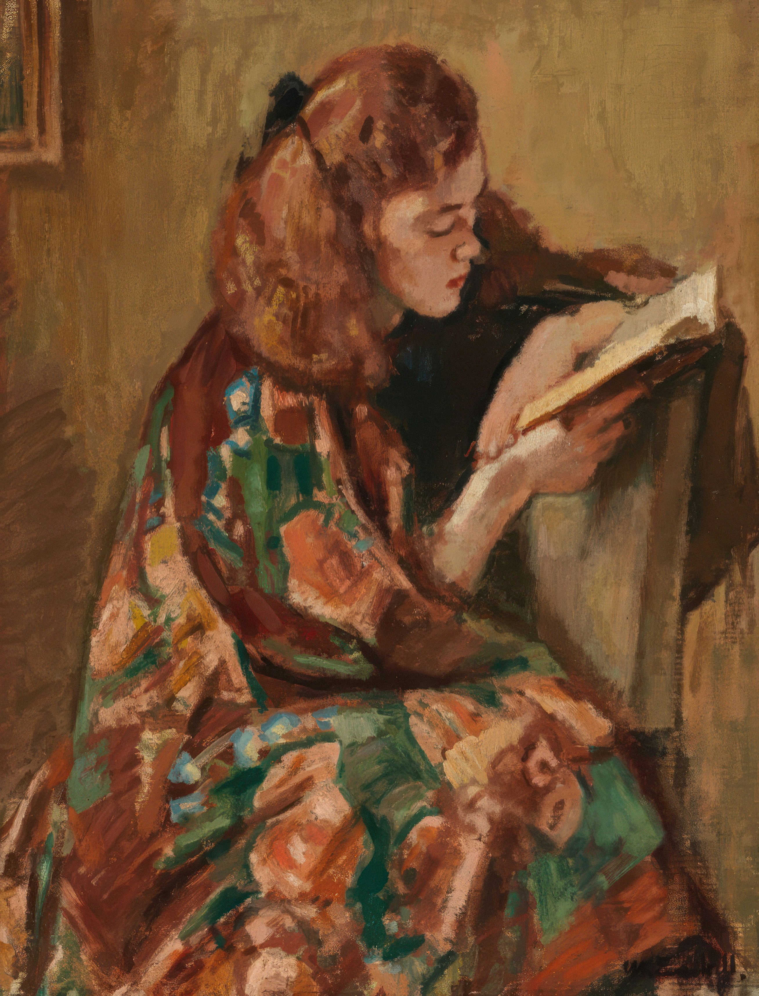 Young woman in colorful robe reads a book.