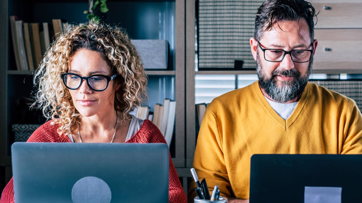 Two workshop participants taking part in a hybrid workshop on their computers