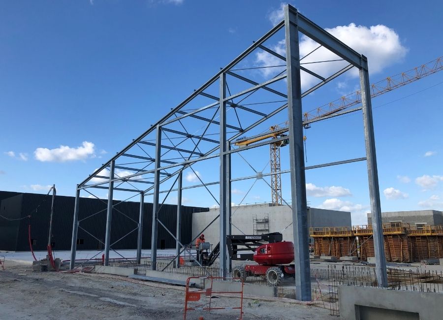 Vue frontale d’une ossature métallique verticale et horizontale, montrant l’avancement du montage.