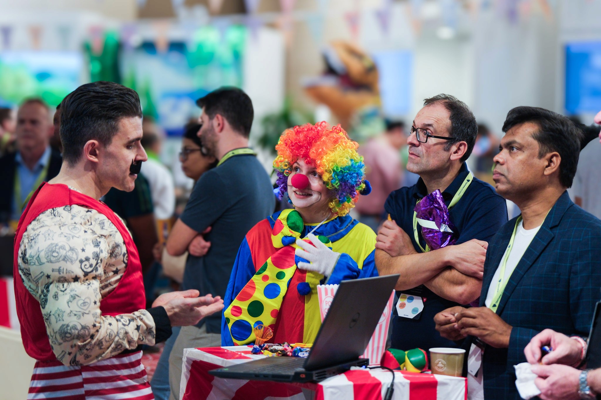A vibrant event scene with attendees in business attire interacting, one wearing a colorful costume.