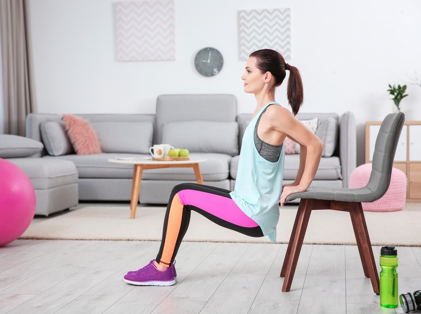 fit young woman doing sitting exercises to lose weight at home in her living room