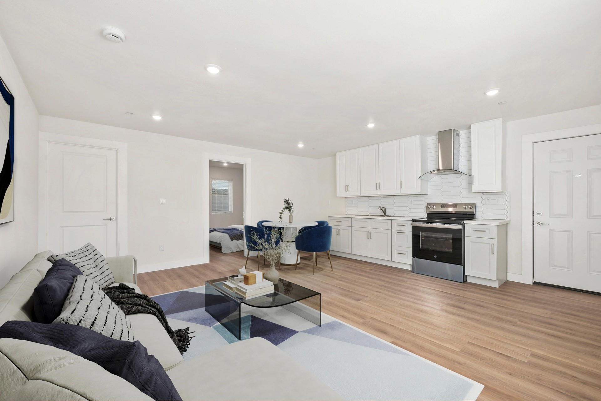 Renovated open living space with modern kitchen, recessed lighting, and designer staging at 1038 E 53rd