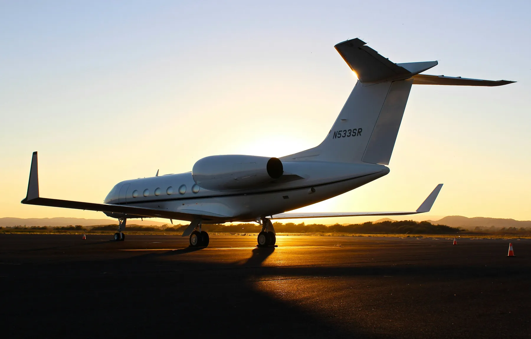 Private jet on the runway at sunset representing charter flights