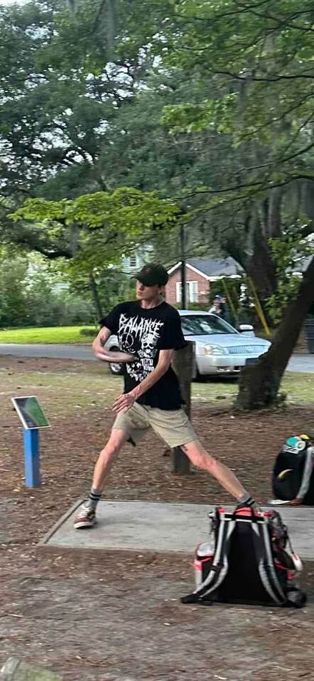 A player throwing on the Park Circle disc golf course under the oaks