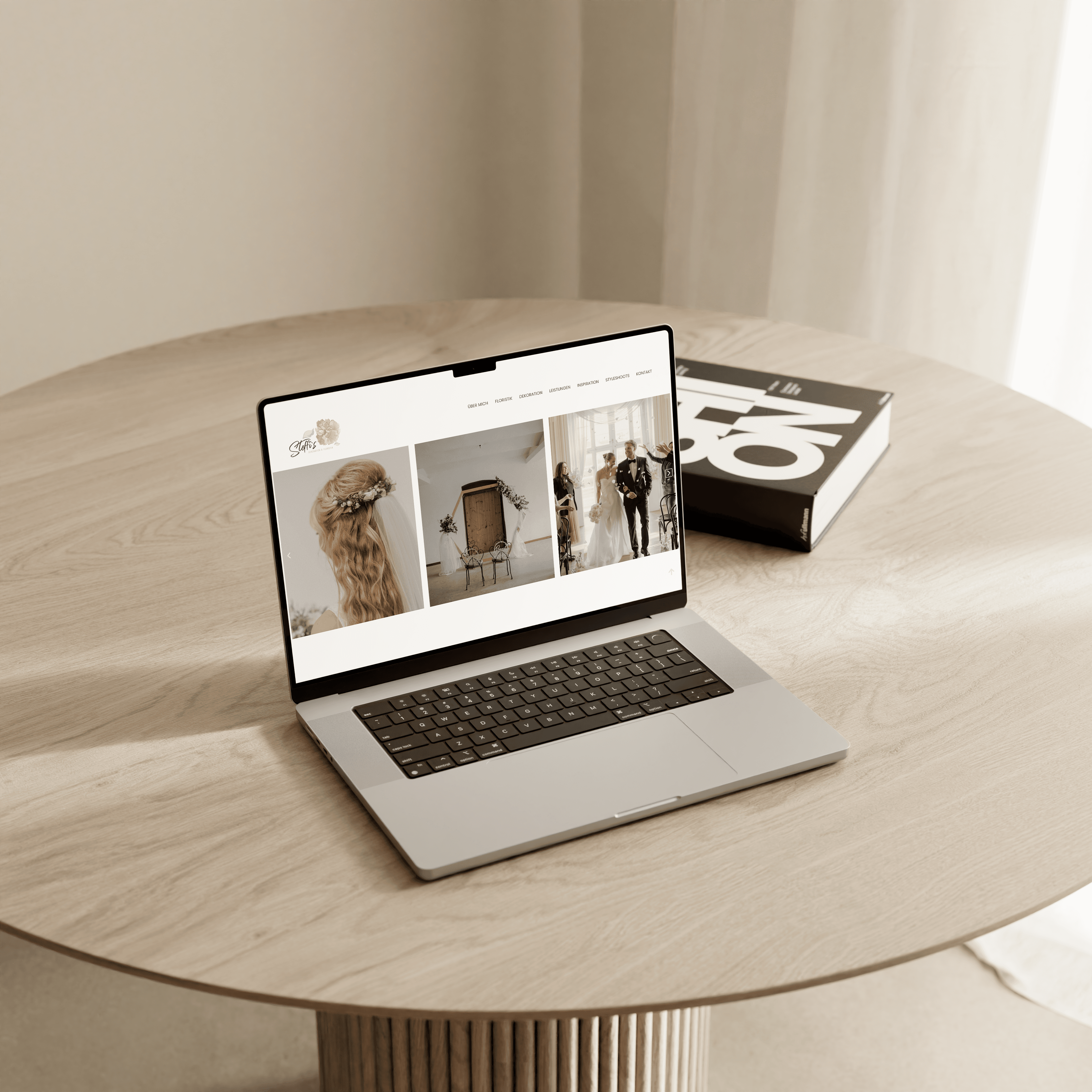 Laptop auf einem runden Tisch stehend, mit einem schlichten Coffee Table Book im Hintegrund. Auf dem Laptop ist eine von OHNORD studio designete Website zu sehen