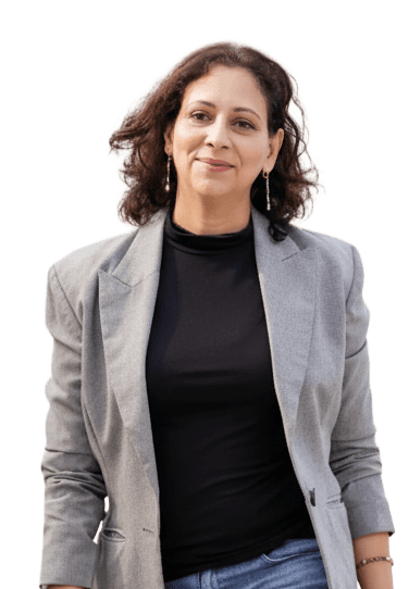 A woman sits cross-legged with eyes closed, wearing a white blouse and a long purple skirt, looking serene.