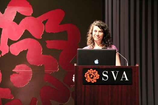 a woman giving a speech from a stand in the "designer as" thesis presentation