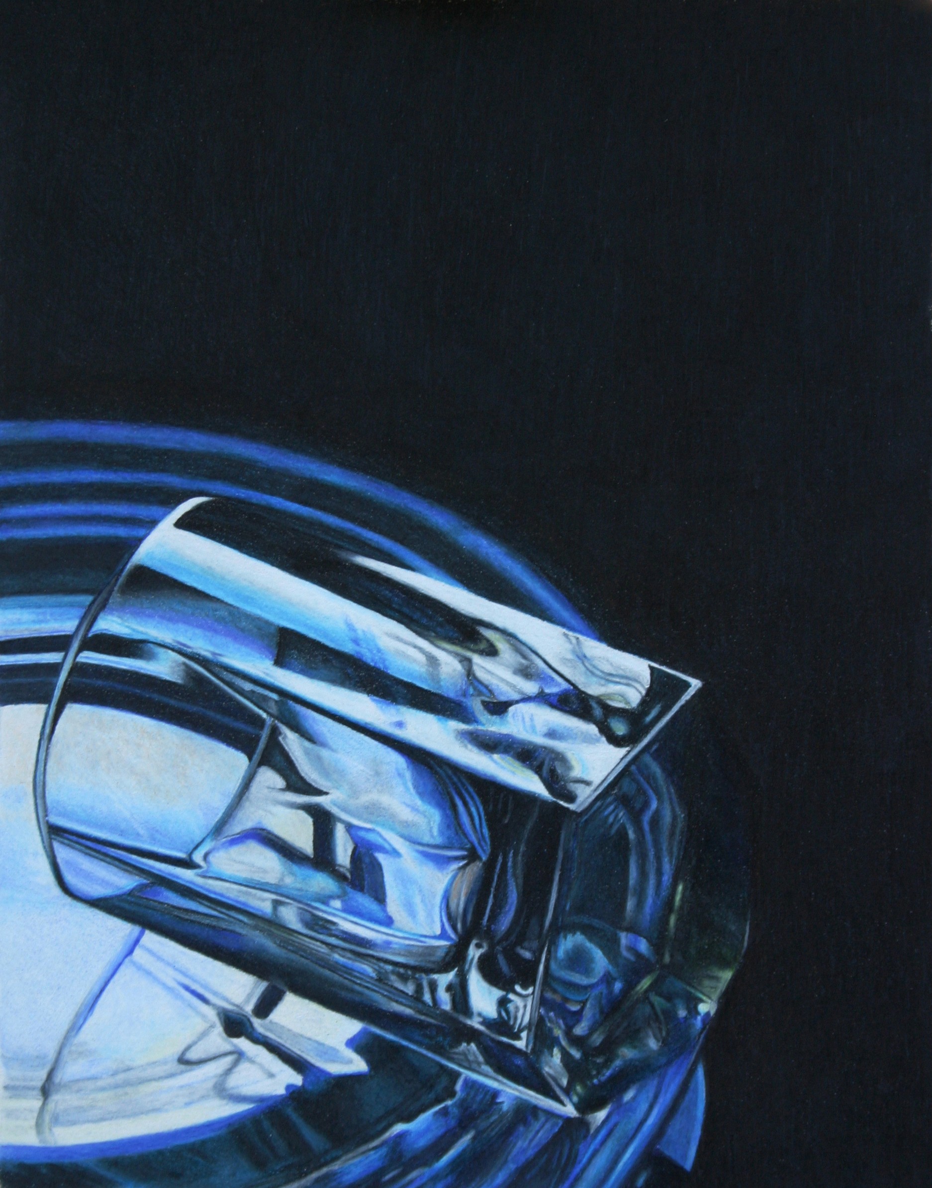 A clear drinking glass laying on a blue glass plate.