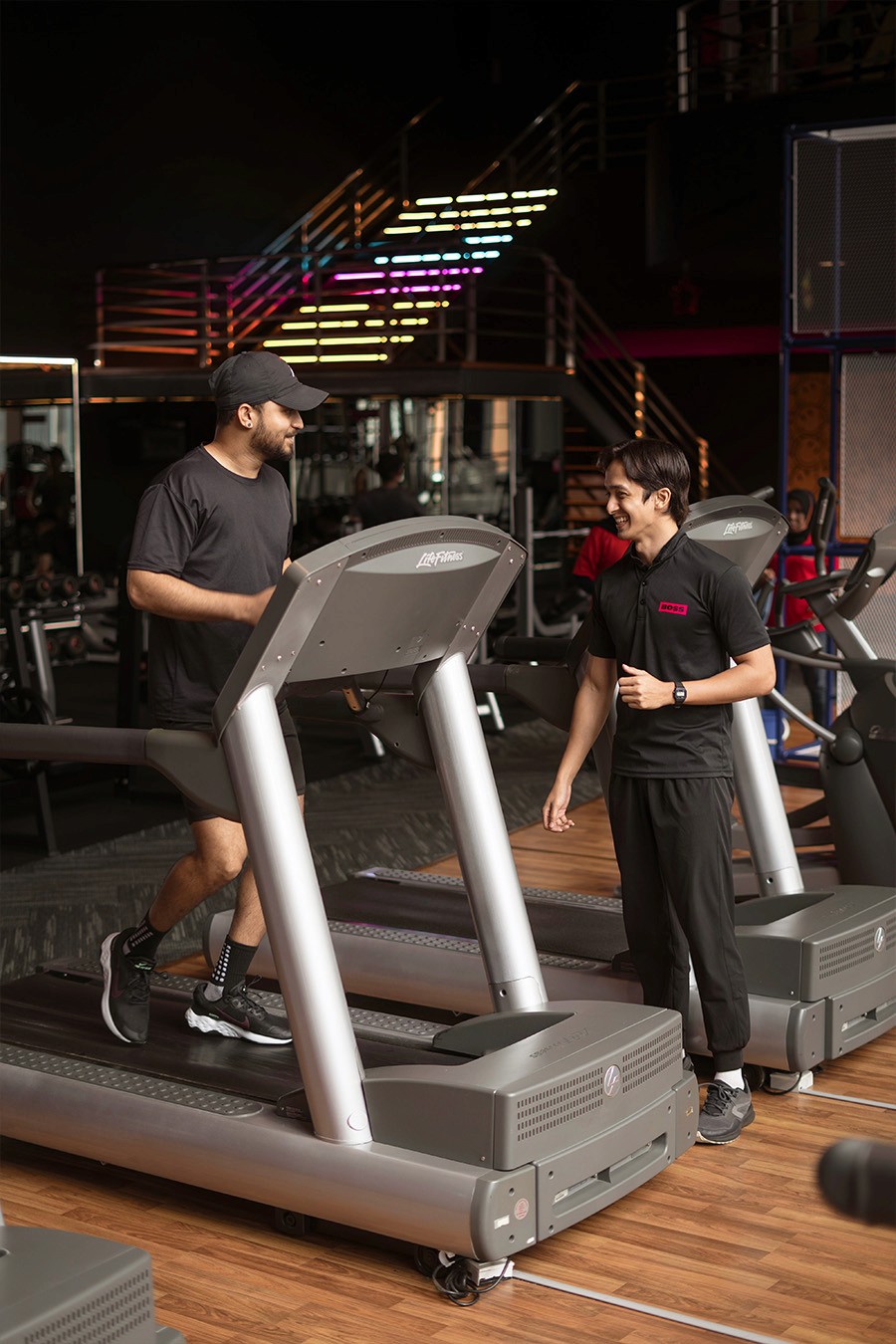 Man Running On ThreadMill With A Personal Training Coach