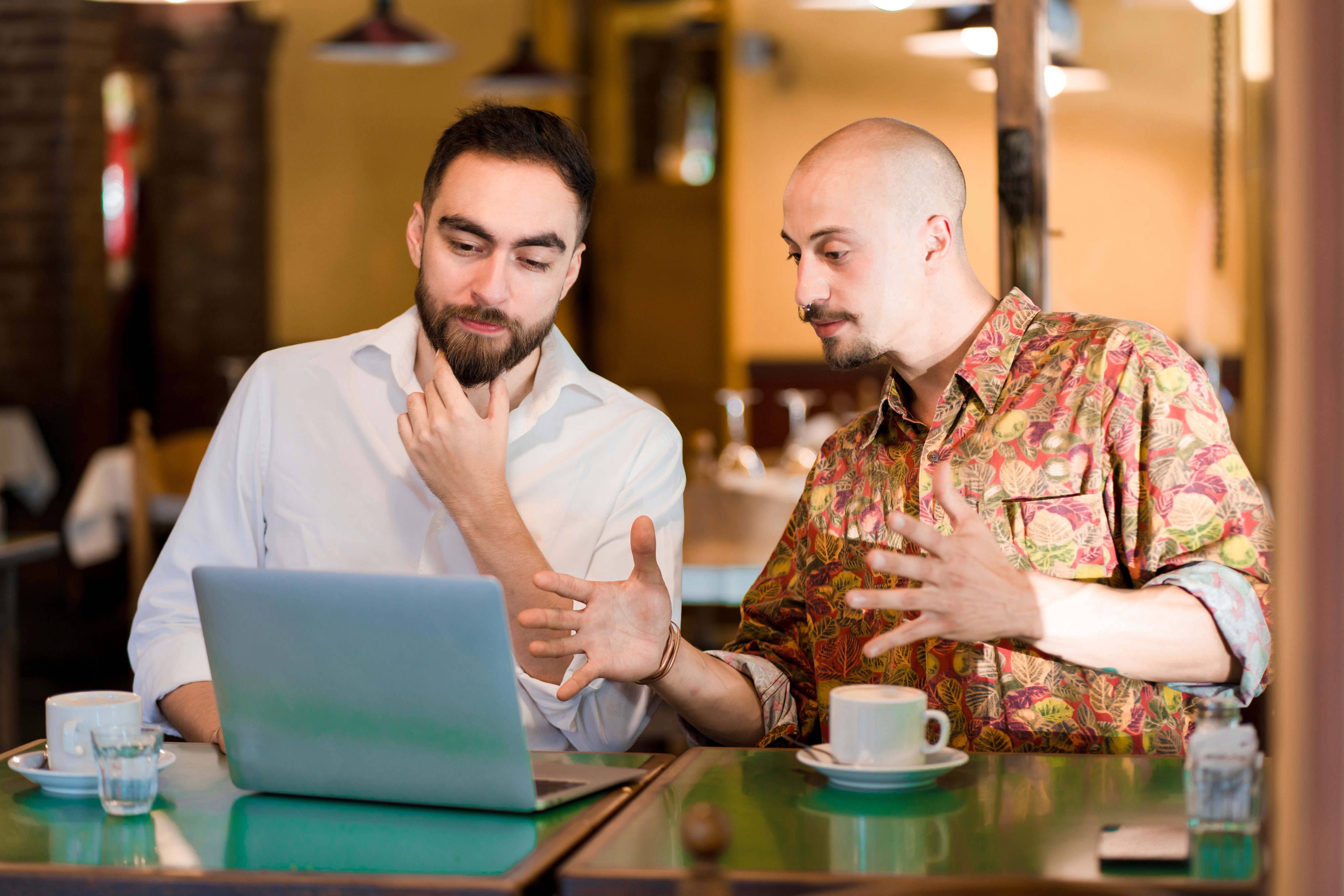 Two people using laptop in coffe shop