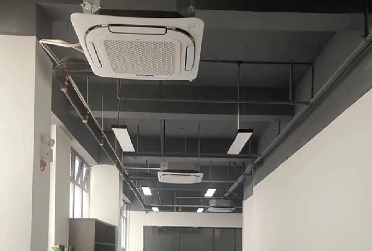 工業風開放式辦公室設計，配備曲面聲學板、室內綠化及人體工學座椅，營造現代感商務工作空間。The industrial-style open-plan office design features curved acoustic panels, indoor greenery, and ergonomic chairs, creating a modern business workspace.