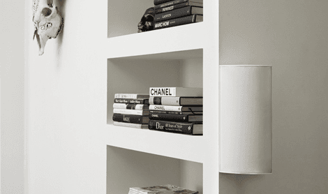 Books on a white shelf with a decorative skull
