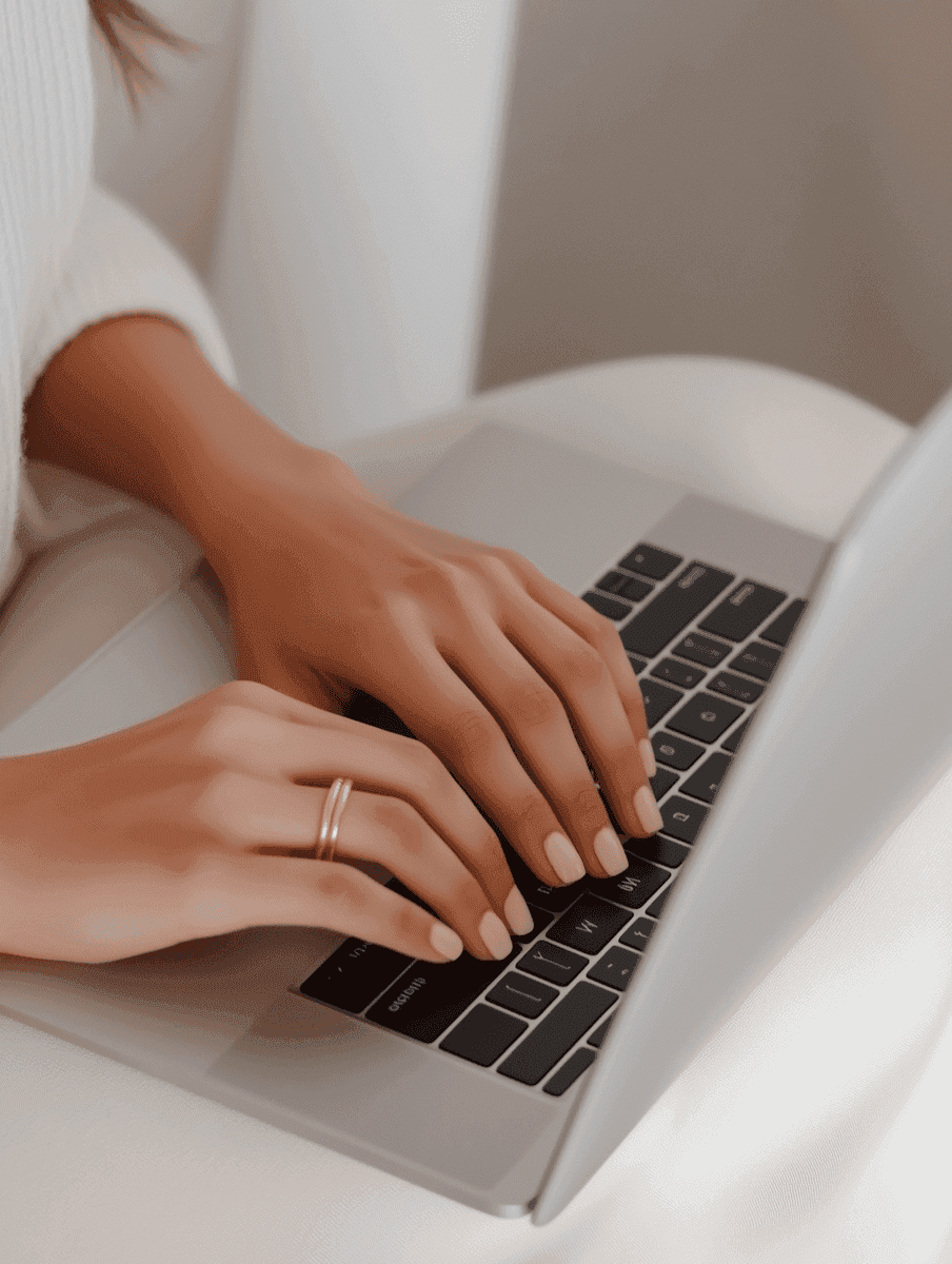 Hands typing on a Macbook
