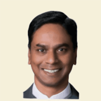 Man with arms crossed in modern office workspace.