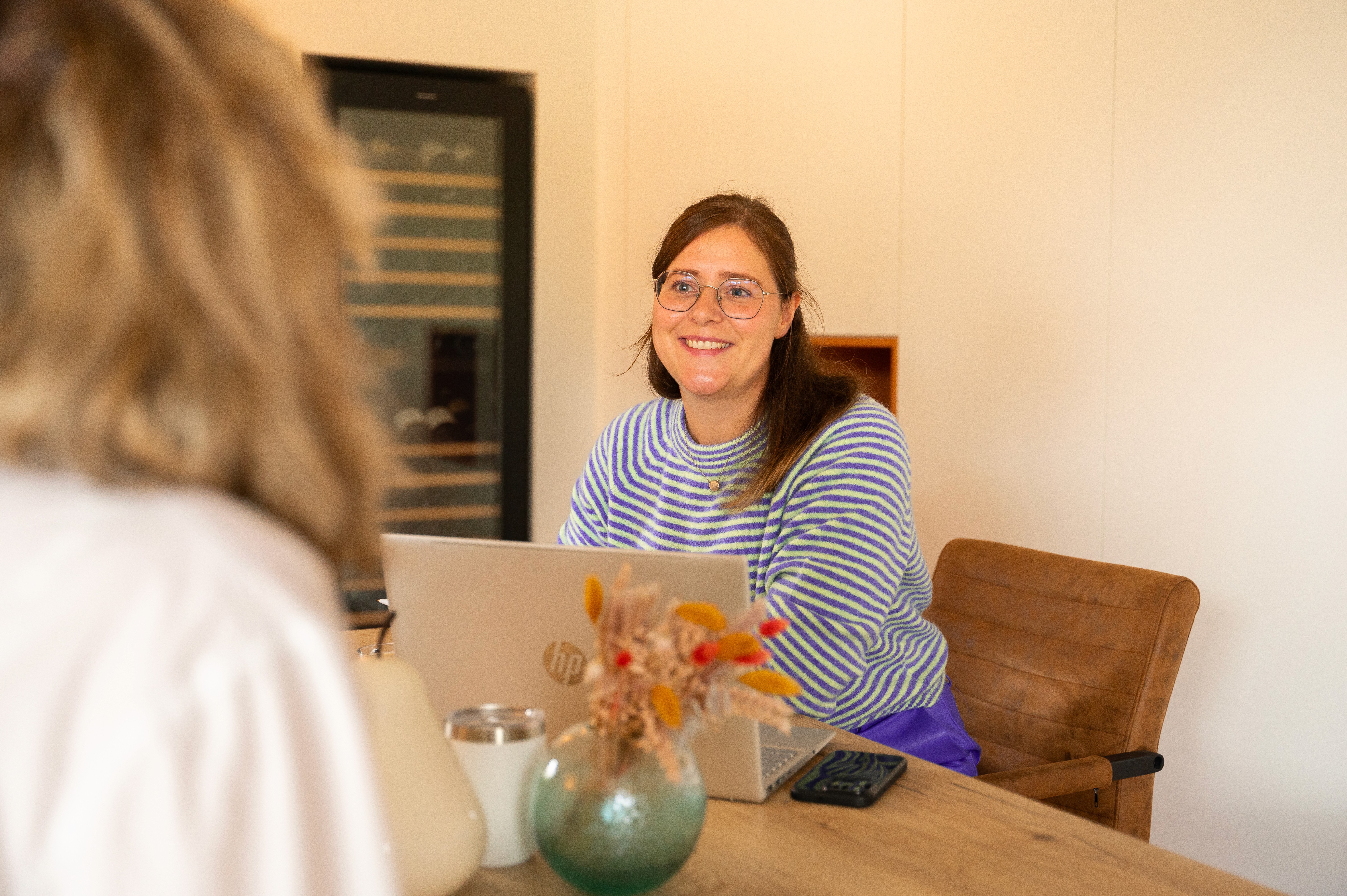 woman sitting around table holding tablet