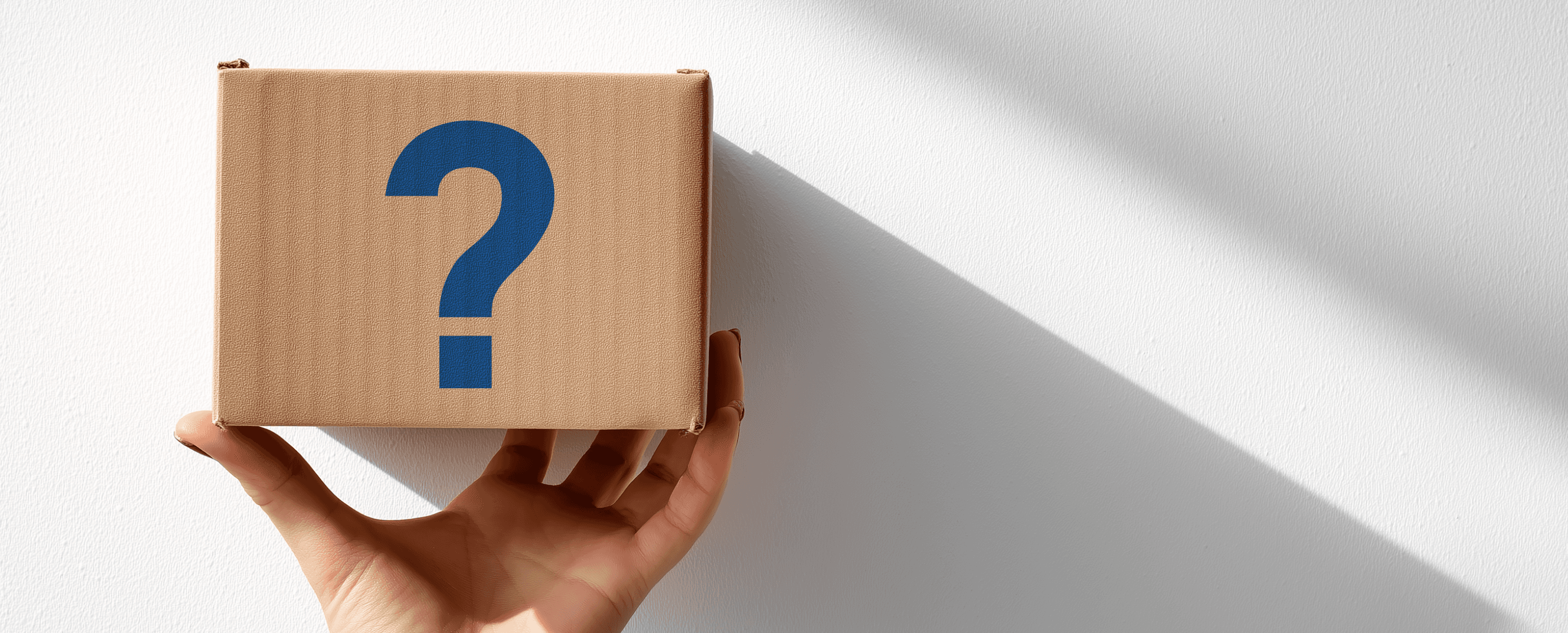 Hand holding a packaging box with question mark label