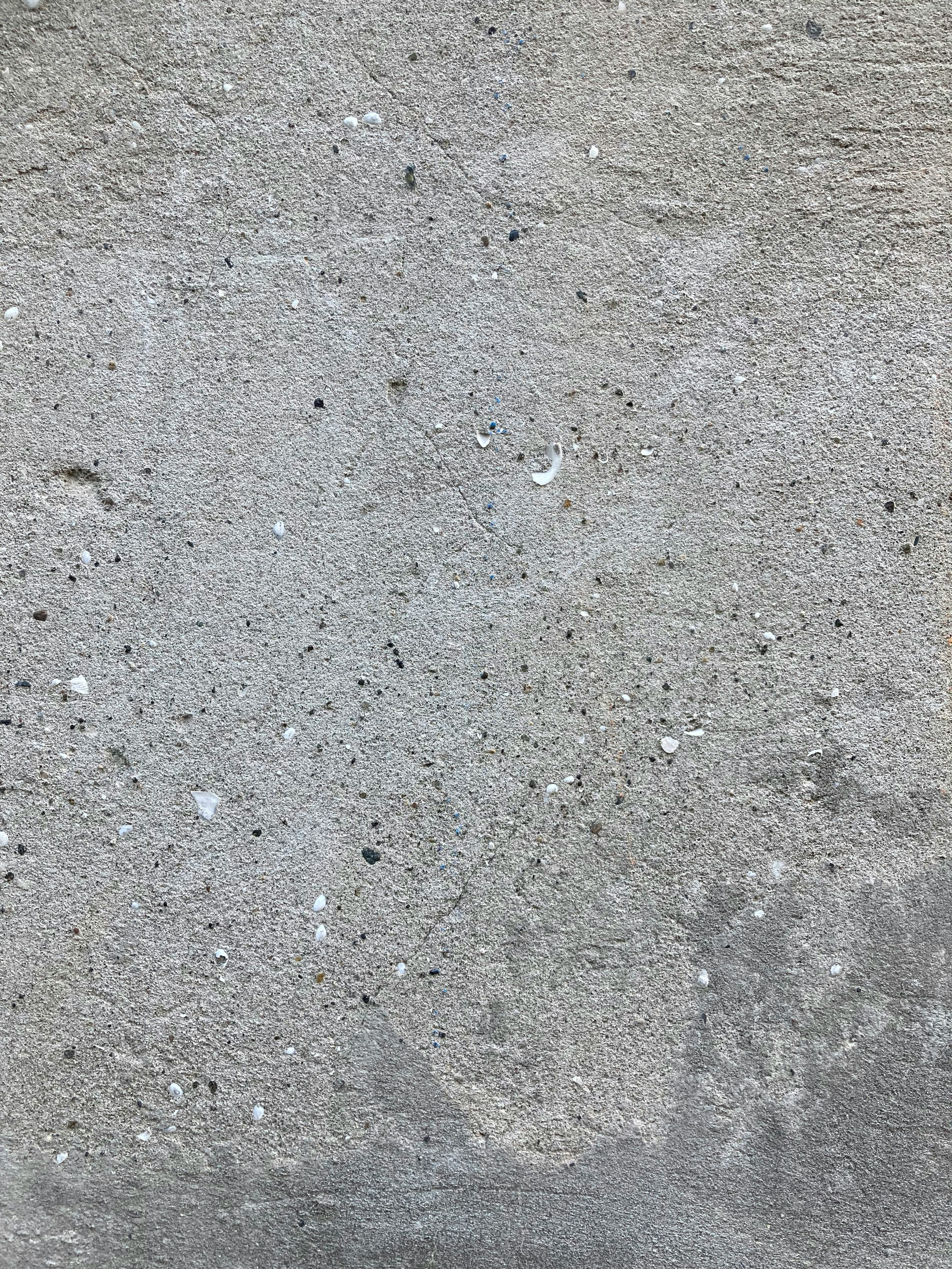 a red fire hydrant sitting on the side of a cement wall