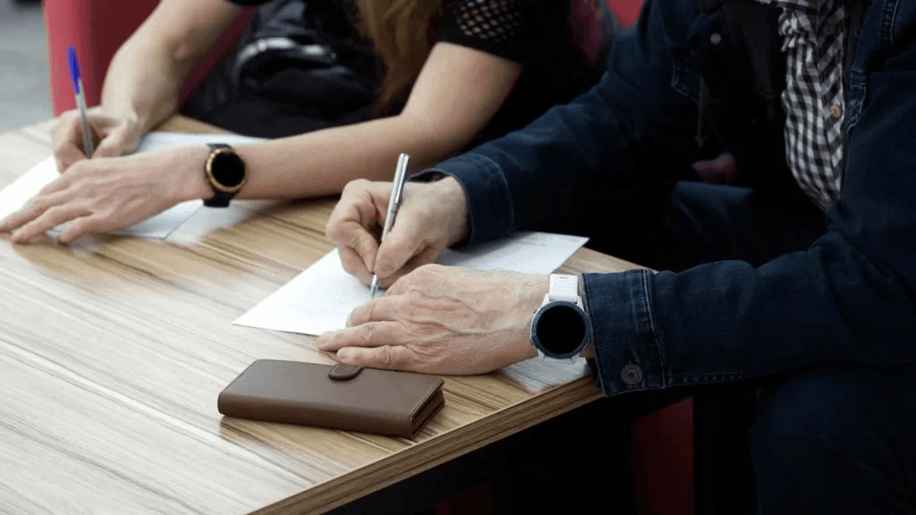 two people signing two documents