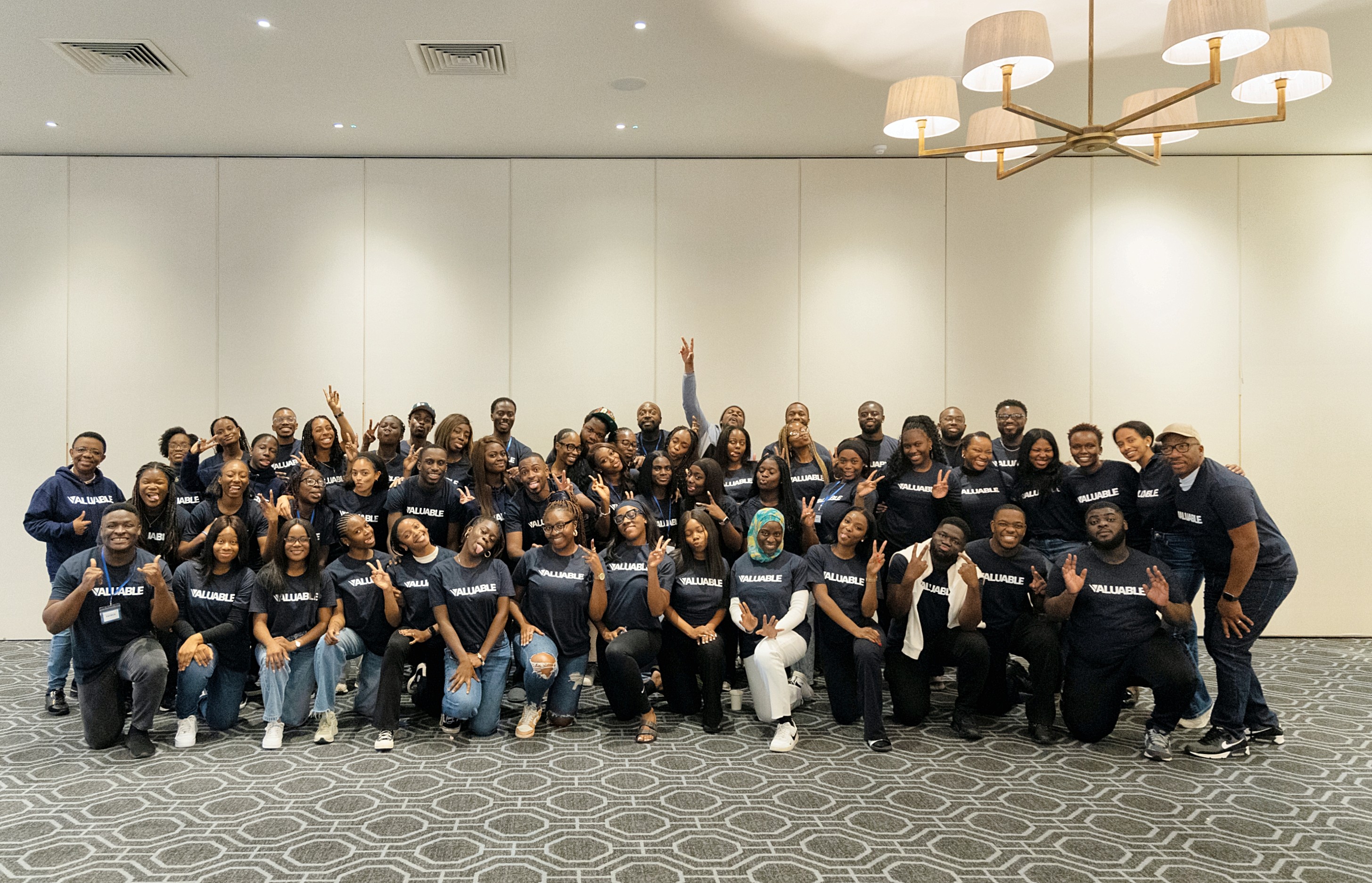 Large group of people from the Valuable community wearing navy sweatshirts, posing for a photo indoors.