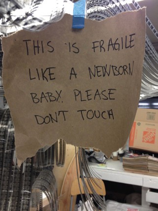 a piece of paper with the message This is fragile like a newborn baby. please don't touch