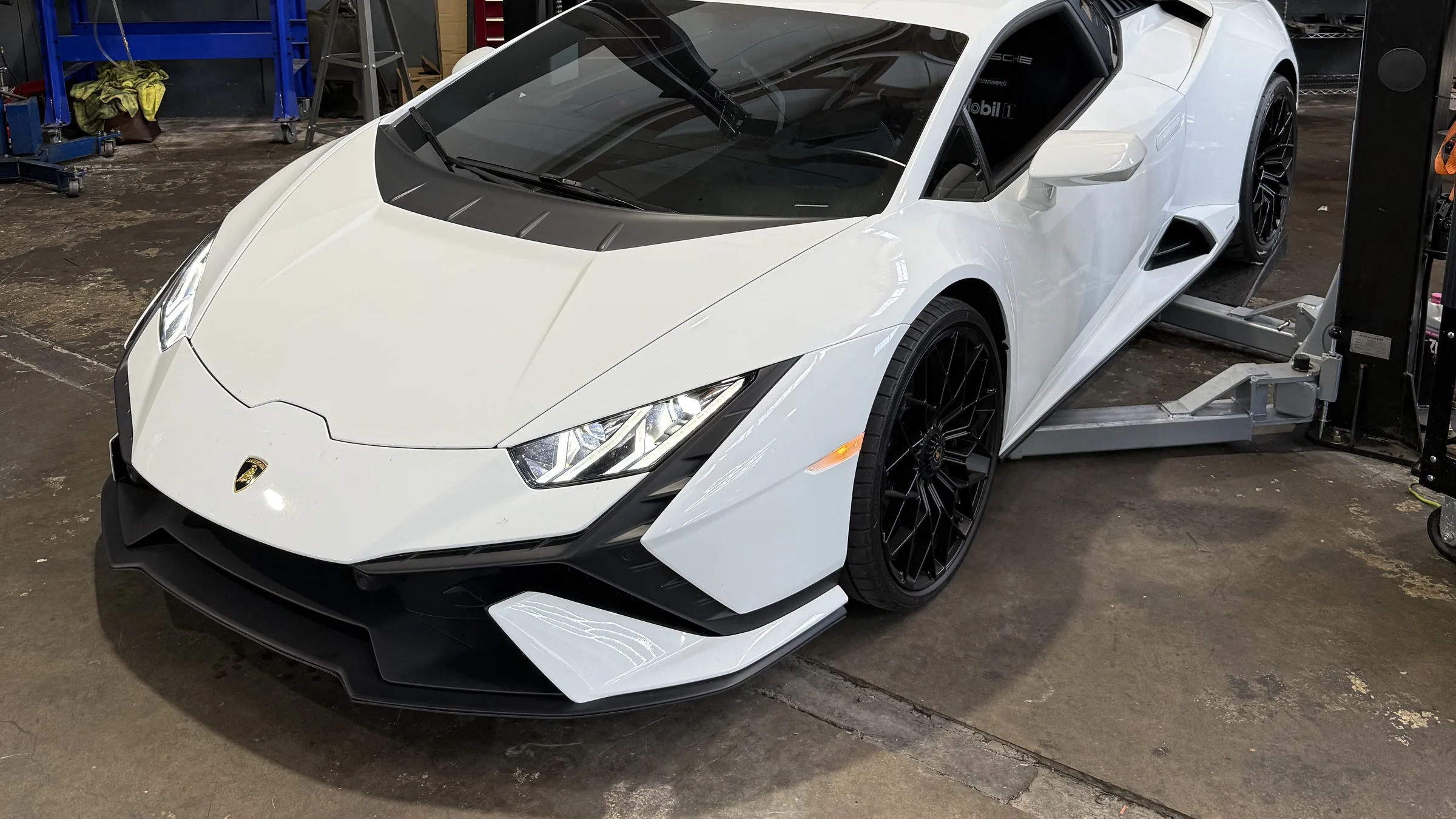 White Lamborghini Huracán with its engine cover raised in the 714 Technik service bay