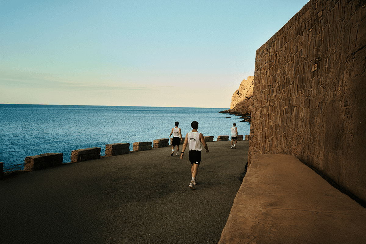 Black and white image of people working at a table with laptops, showing hands gesturing during discussion of digital content displayed on screens, with fabrica® logo in the corner.