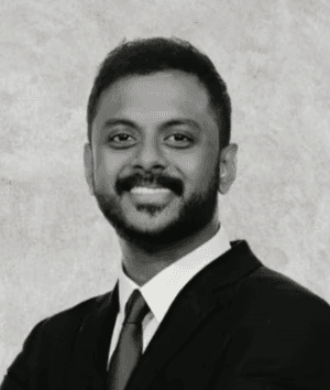 Close-up of a dark green leaf showing its textured surface and central vein against a muted background.