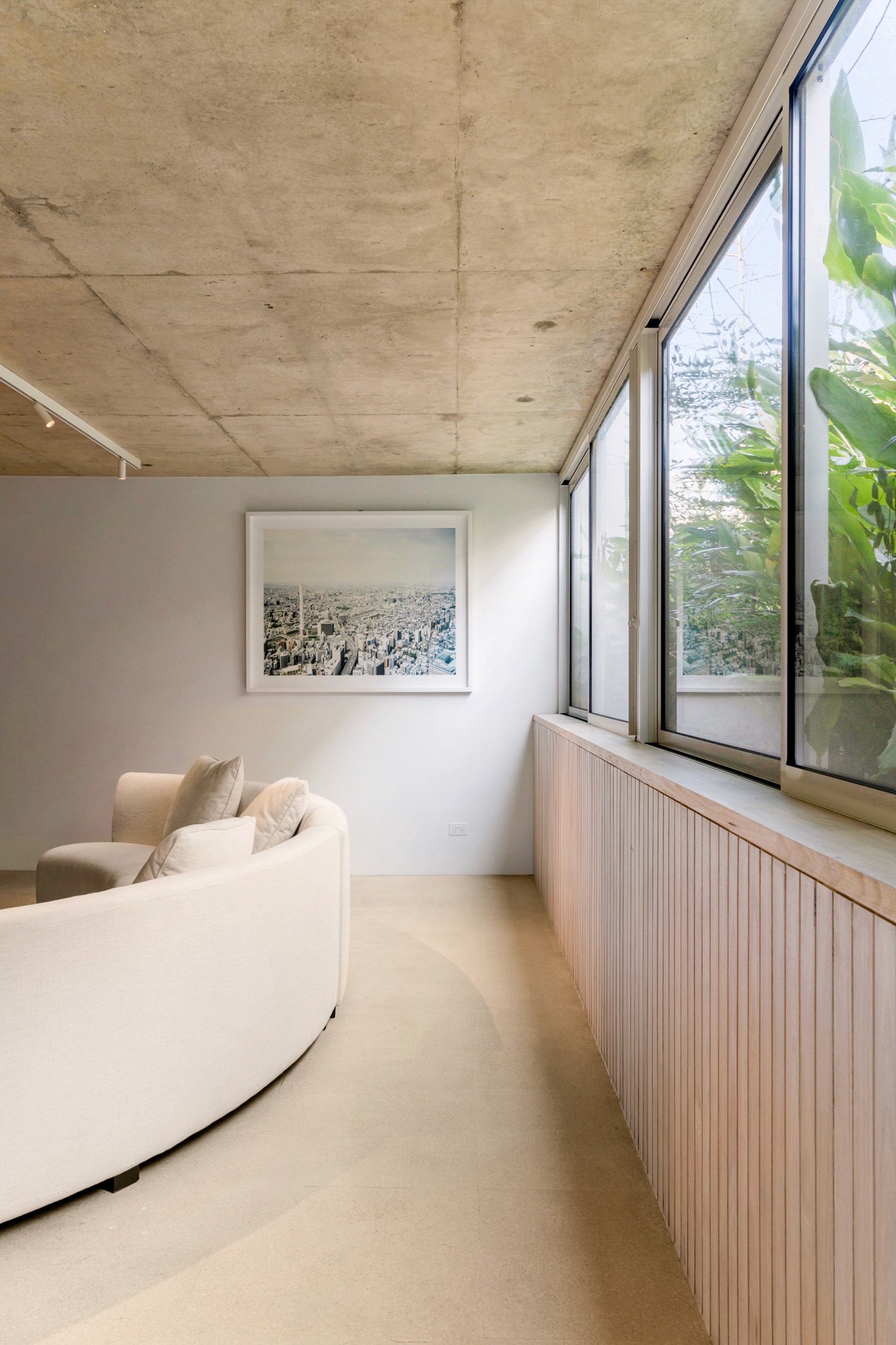 Modern swimming pool with lush green plants and flowers.