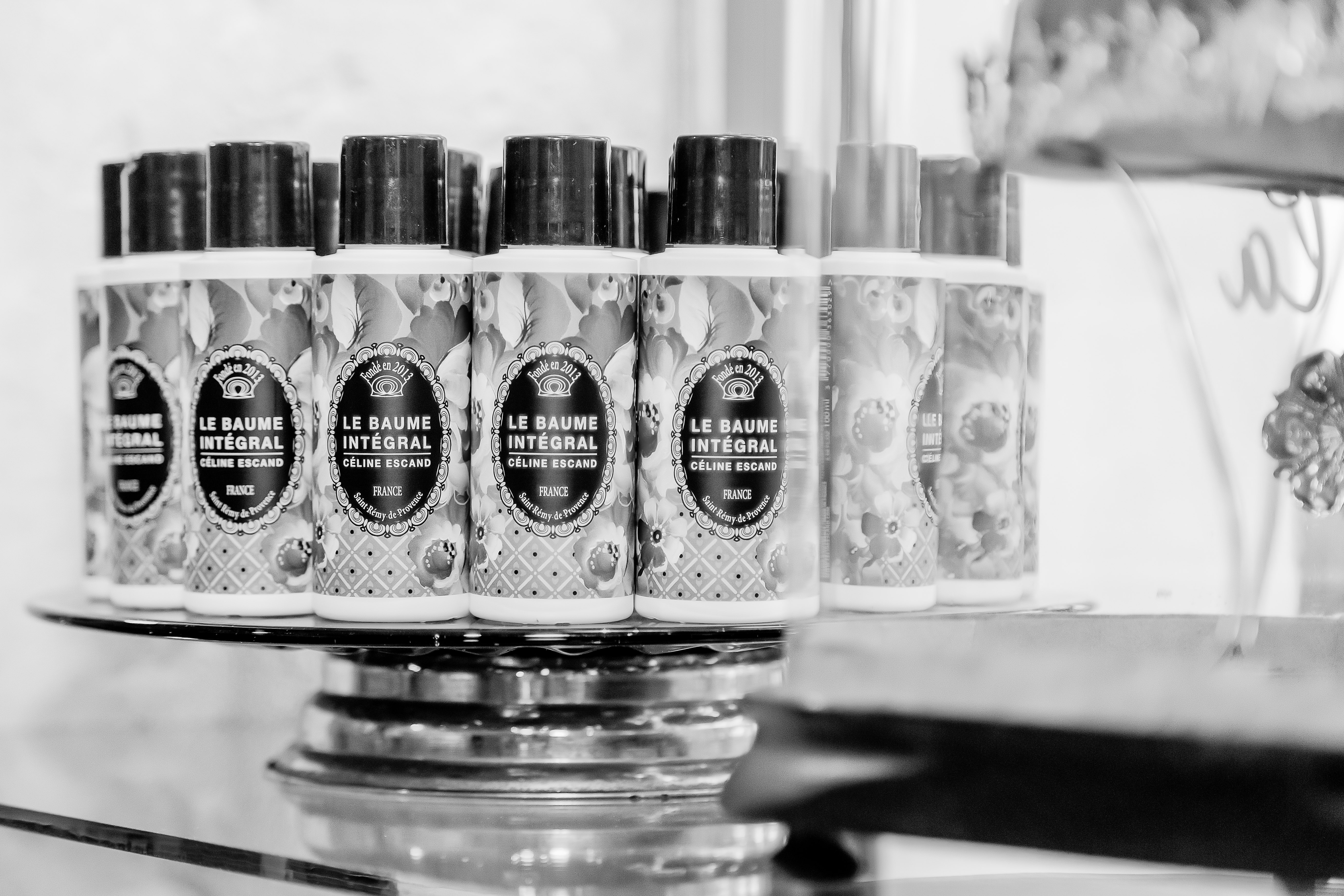 Plusieurs flacons du Baume Intégral Céline Escand alignés sur un présentoir, mettant en valeur un soin français artisanal haut de gamme.