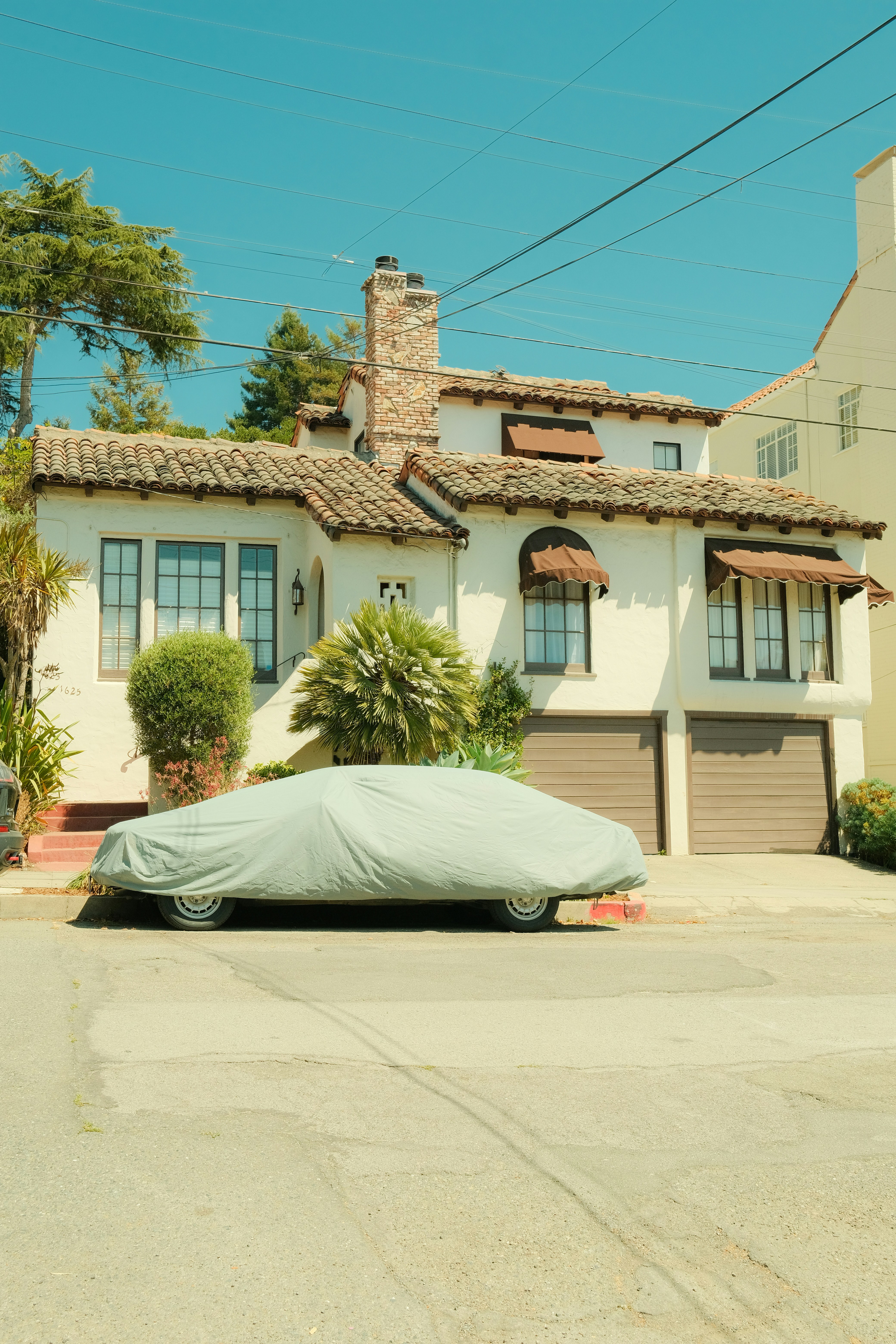 House with car covered in tarp