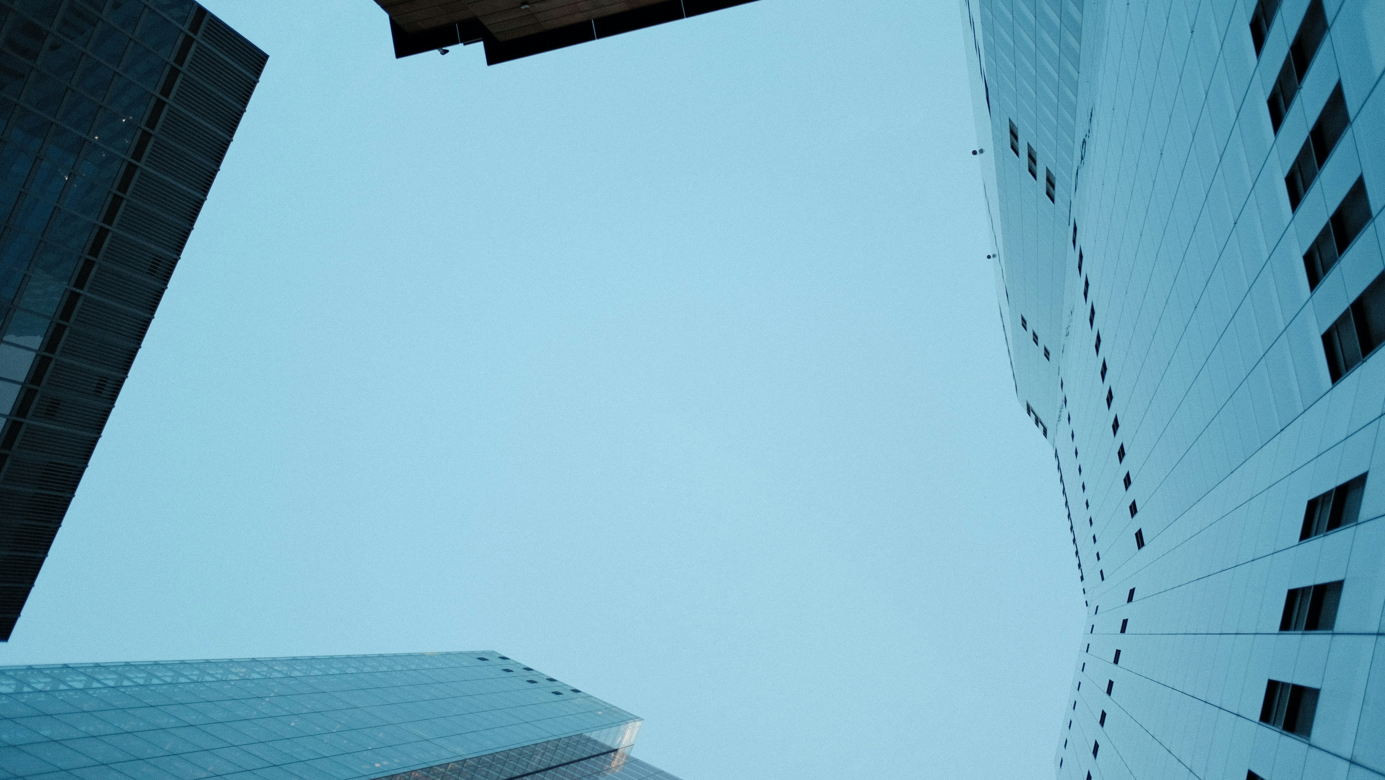 Looking up at tall buildings against a clear sky