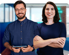 Empreendedores, homem utilizando notebook e mulher usando celular olhando diretamente para a camera, ao fundo a cidade de Porto Alegre