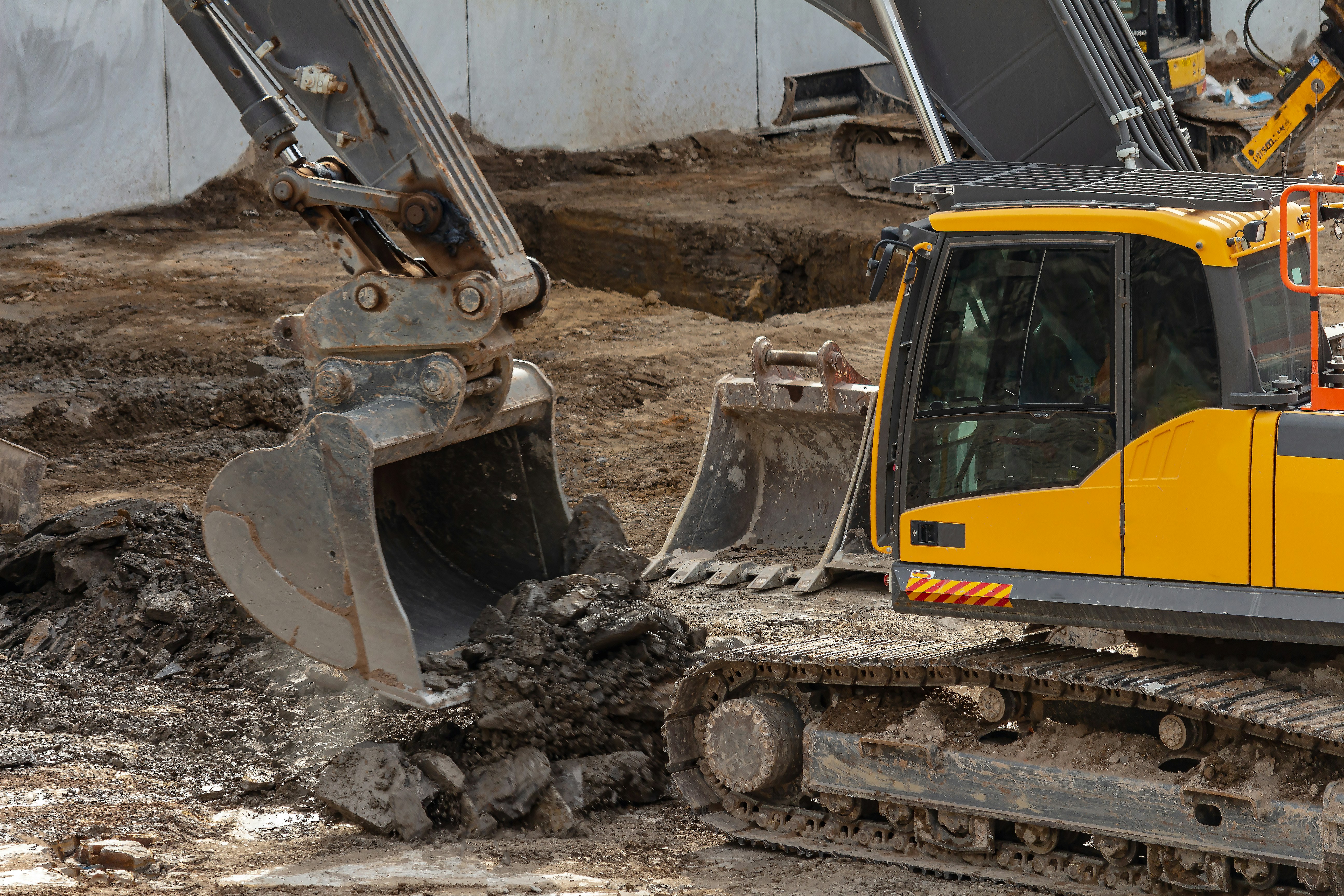 yellow and black excavator on brown soil