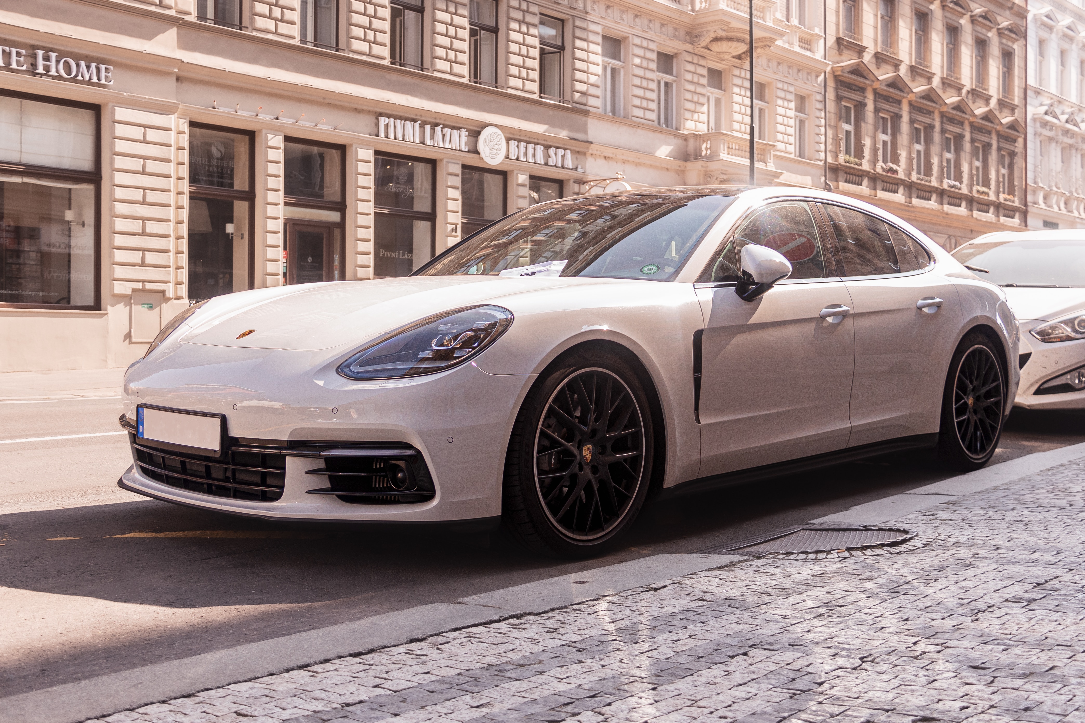 A white porsche parked on the street during day