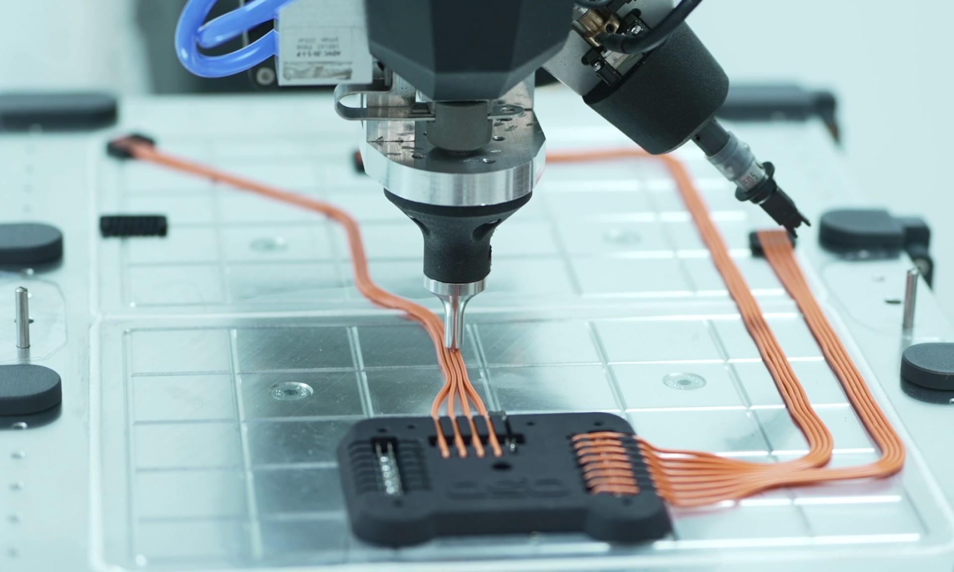 A photo showing a machine automating wire harness manufacturing