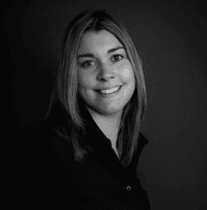 Young man in glasses smiling at the camera