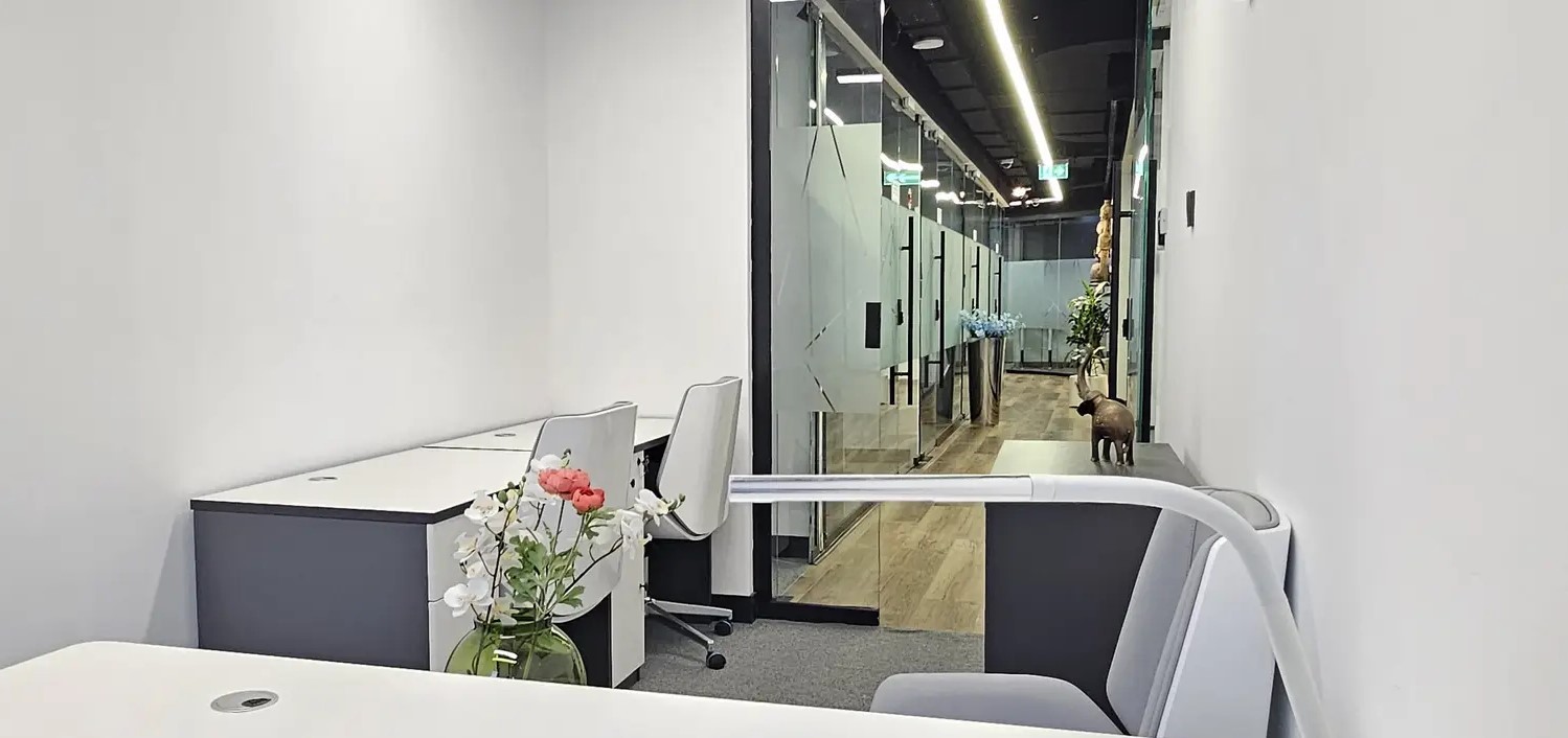 Professional office corridor featuring contemporary glass offices and high-end finishes for lease.