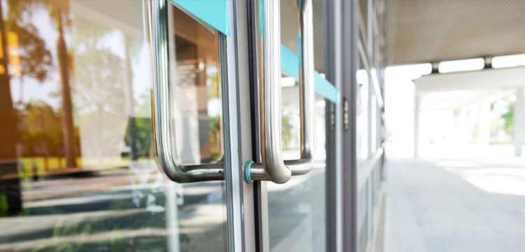 Side view of a Calgary business's aluminum glass door with aluminum handles, captured on a sunny day.