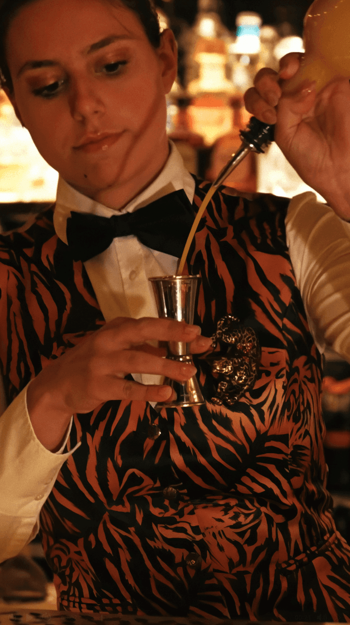 Dancer in black outfit with arms raised, arching backwards