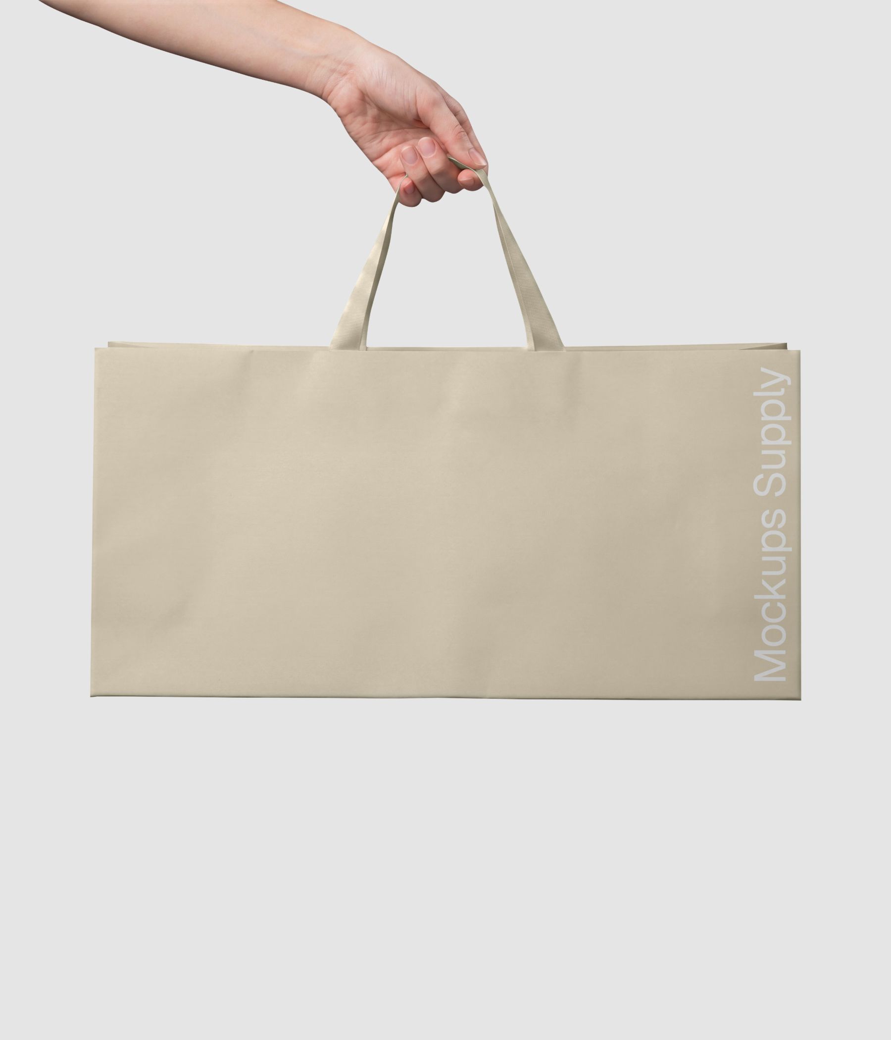Hand holding wide paper bag mockup with ribbon handle for gift branding download