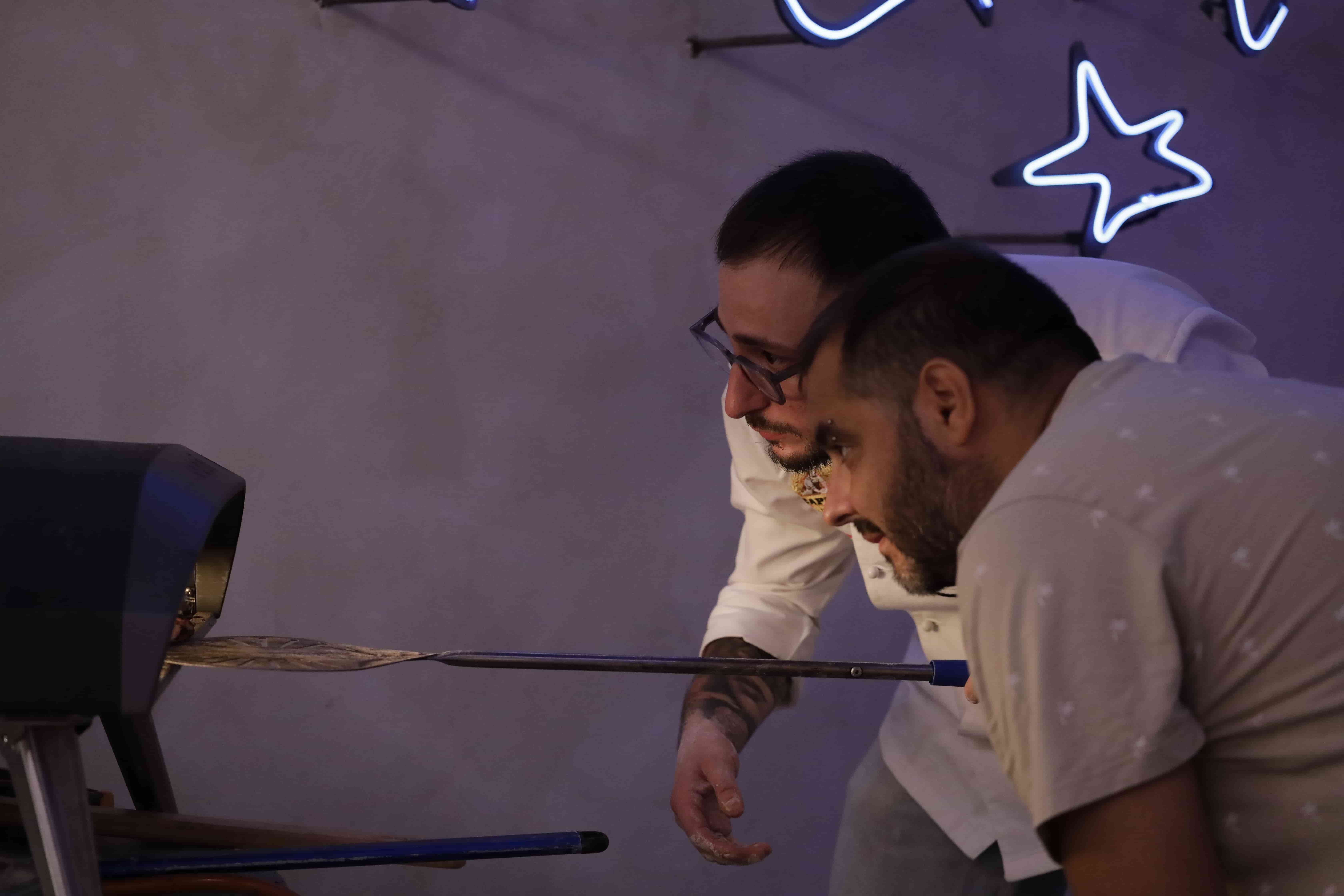 Santopizzaiolo putting a pizza into the oven on a napoletanean pizza workshop 