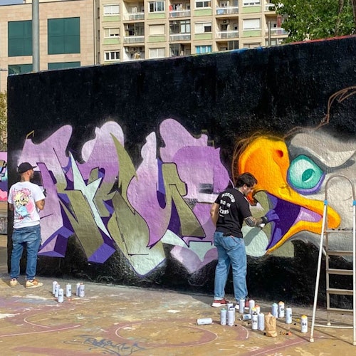 街头艺术家正在城市墙上创作作品的过程中。