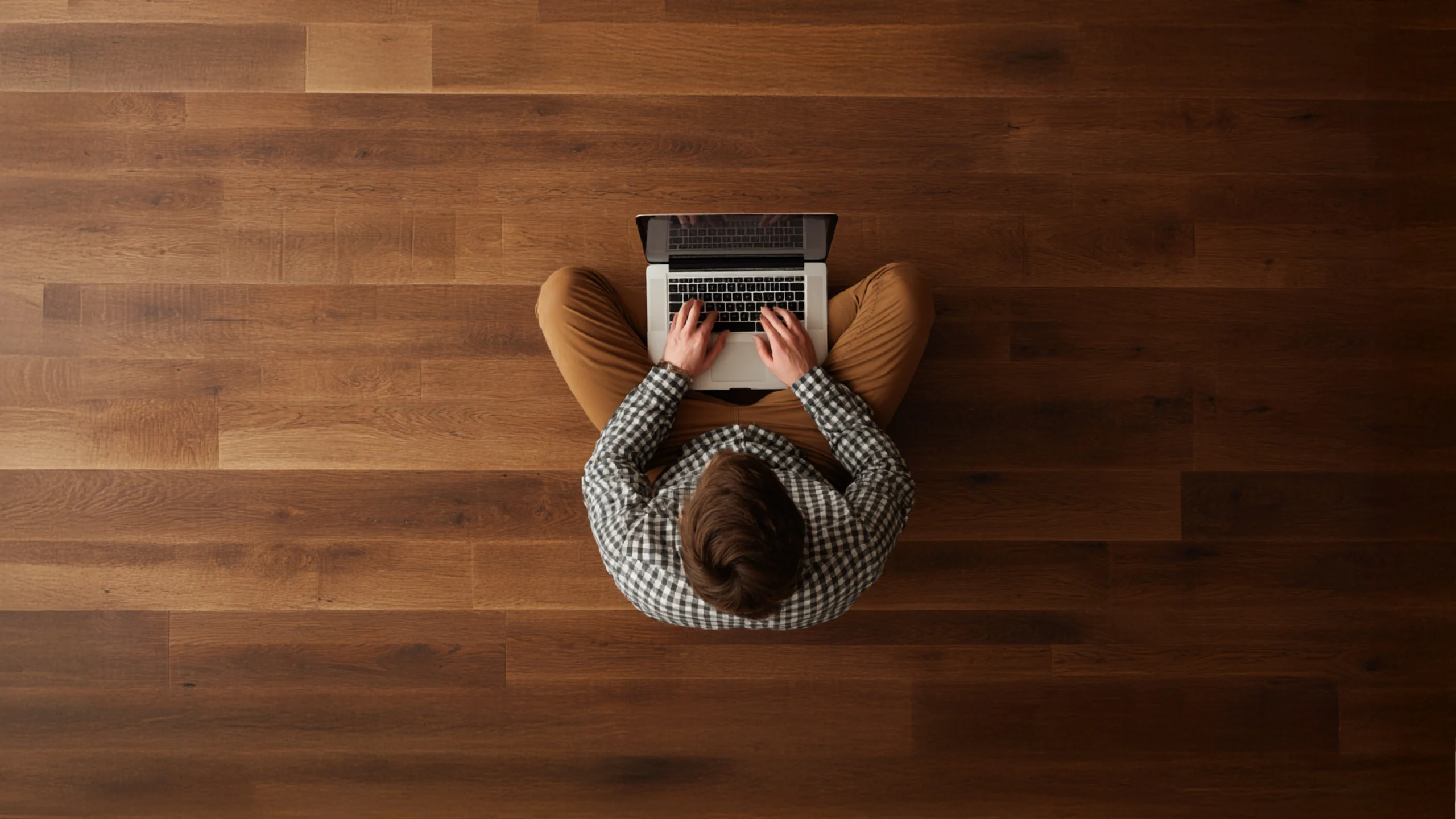 A top-down view of a wooden table with a grey woolen bowl and a brown cardboard box beside it.