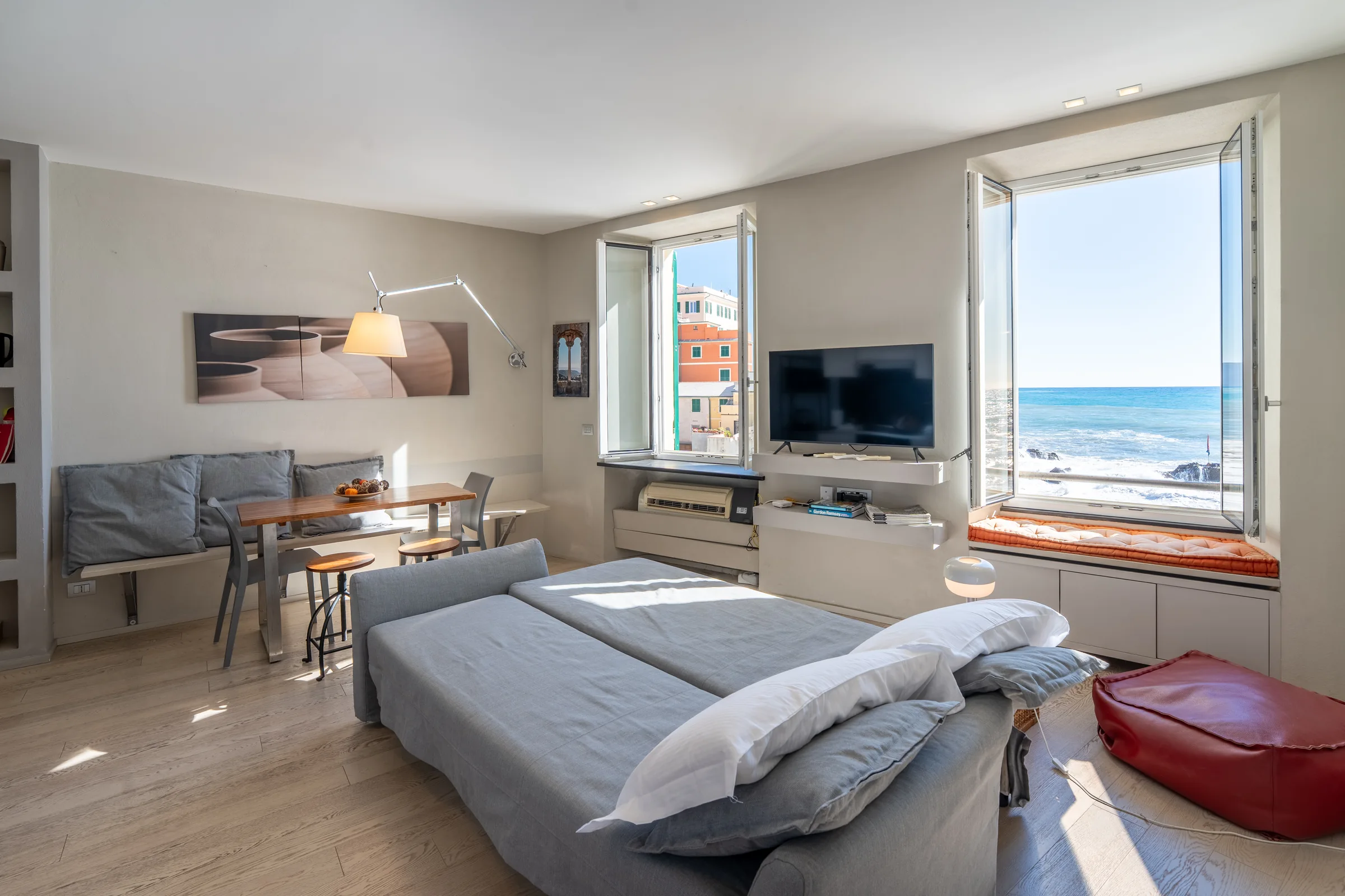 Apartment living room with a window onto Boccadasse harbour — Boccadasse, Genoa, Italy. Photography by Yunes Calore.