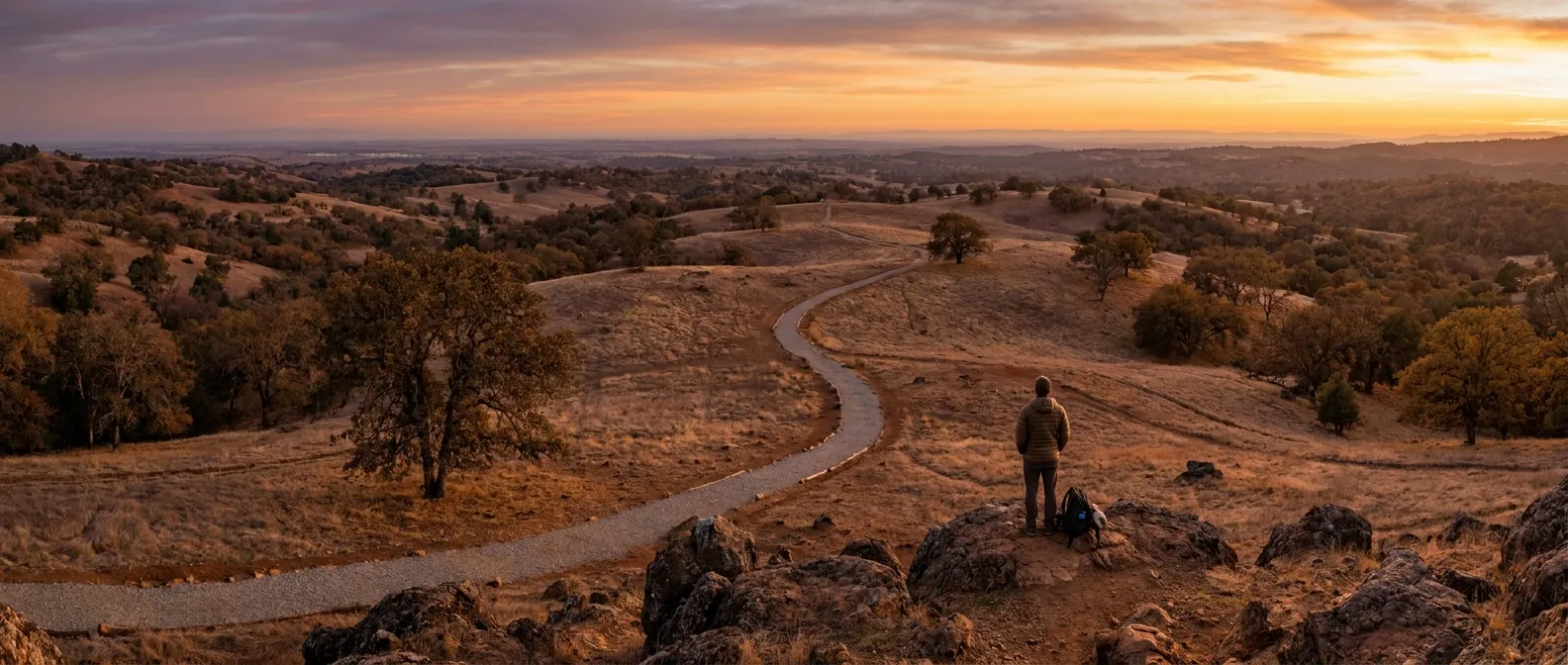 Person on hill at sunset, overlooking landscape; RockN' Socials Digital Marketing Agency.