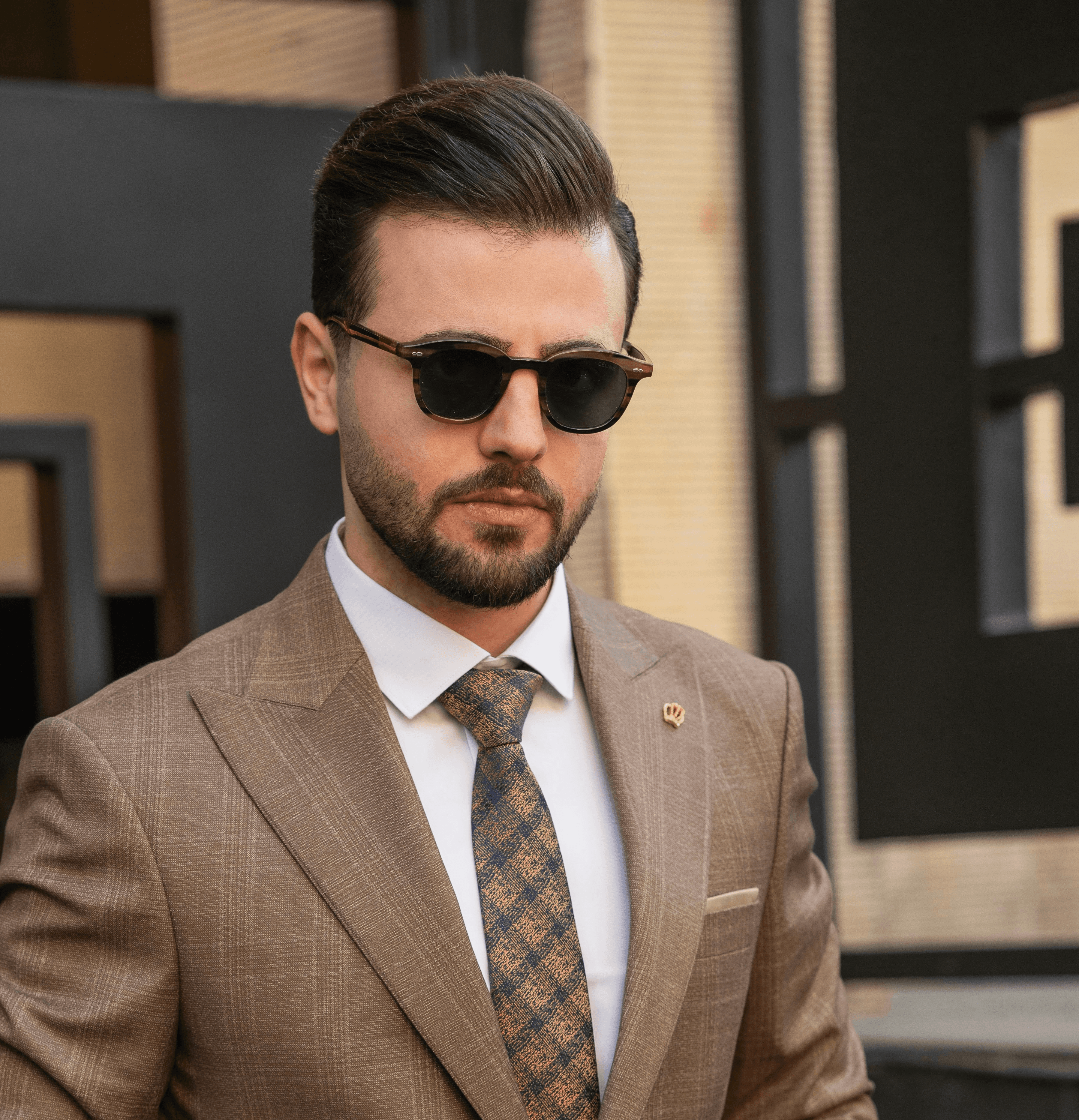 a man in a suit and sunglasses standing in front of a building