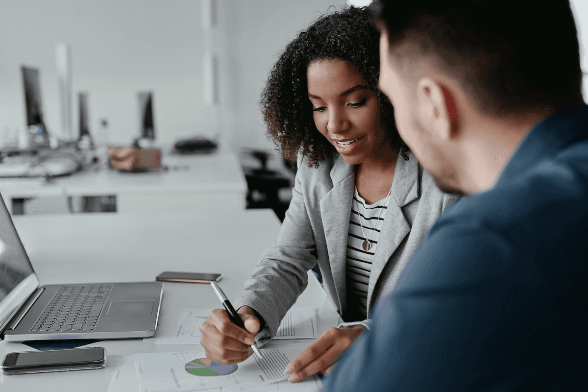 SaaS metrics: Woman discussing a report with her colleague