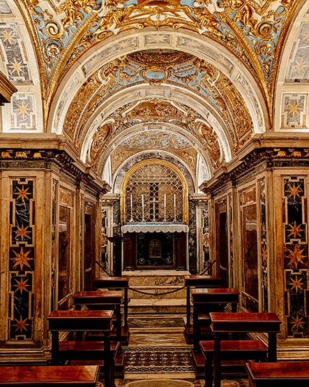 Частный гид в Риме — Узкий проход древнего римского некрополя под землей с кирпичной кладкой и остатками фресок при тусклом свете.