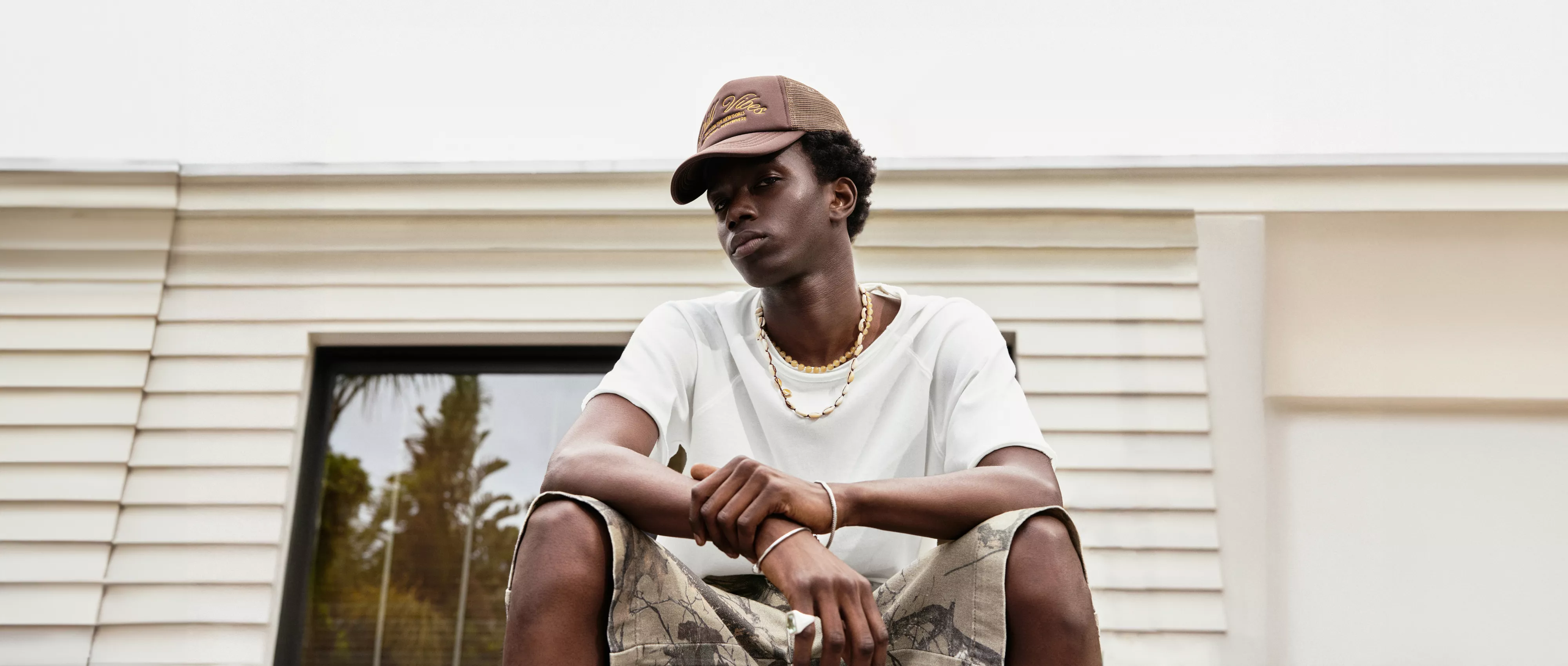 Male model in a gray hoodie, posing casually.