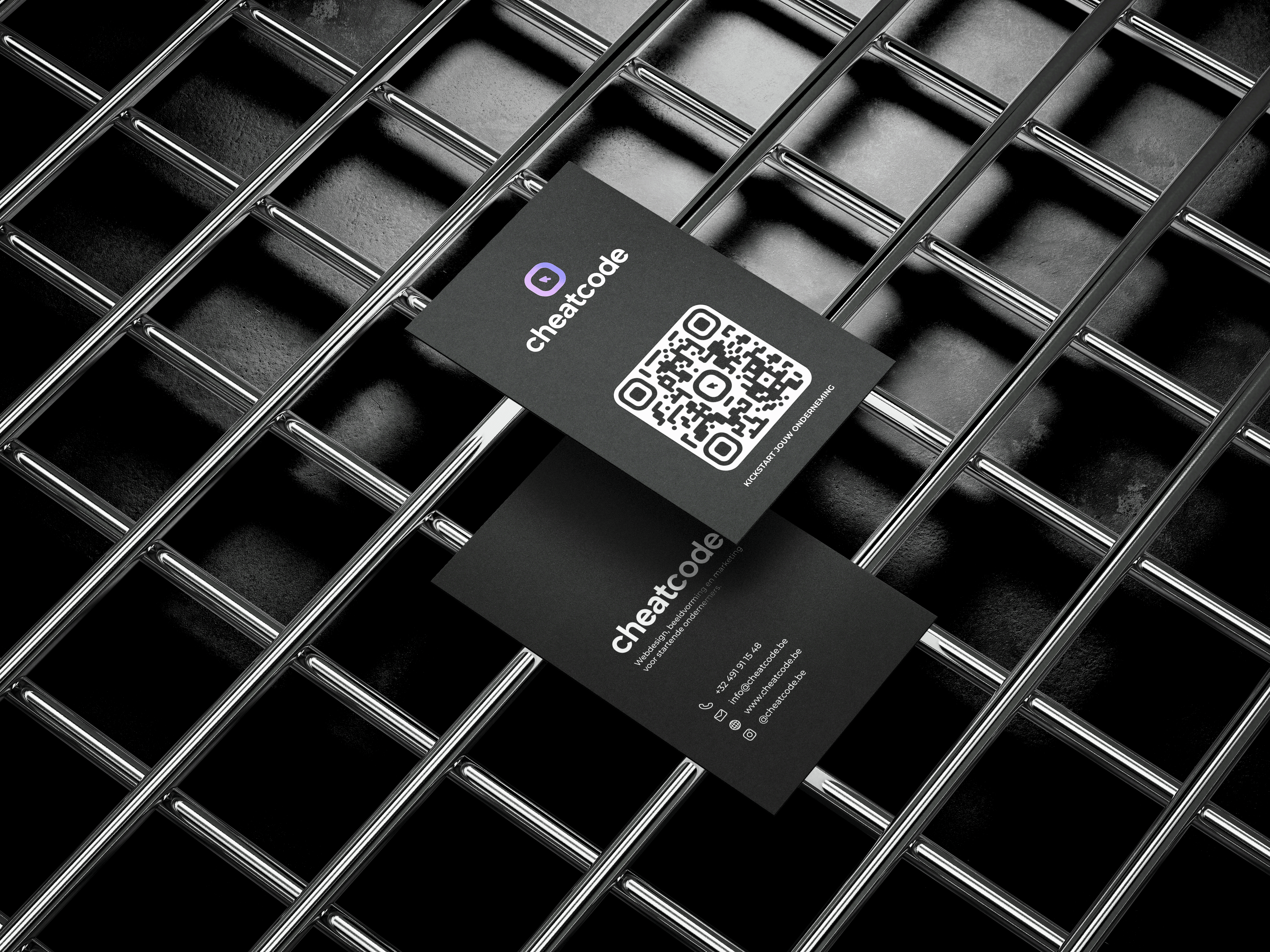 Black CheatCode business card mockups with logo and QR code displayed on a metal grid.